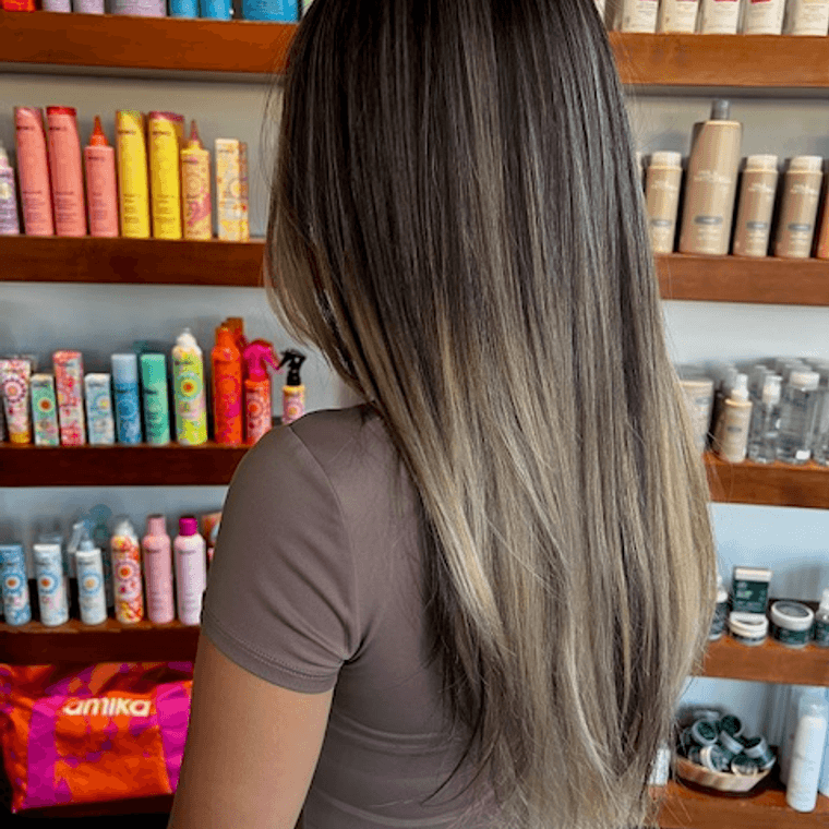 Long balayage melting from a dark root into blonde ends, by Ciara